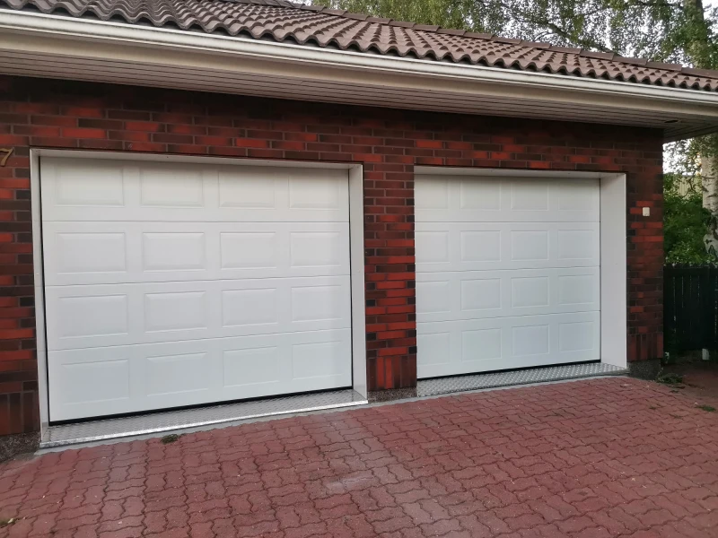 Autotallin nosto-ovet asennettuna turkkipeltikynnys ja peltipielet peilikuvio — JK-Ovet