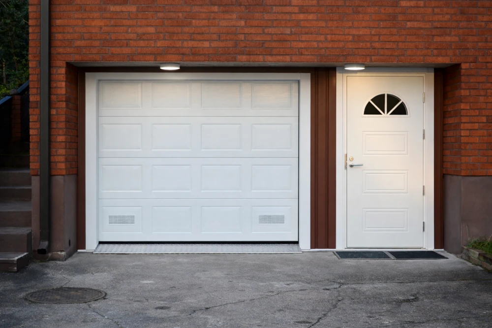 Autotallin nosto-ovi asennettuna Kotkassa — peilikuvio puunsyy valkoinen — JK-Ovet