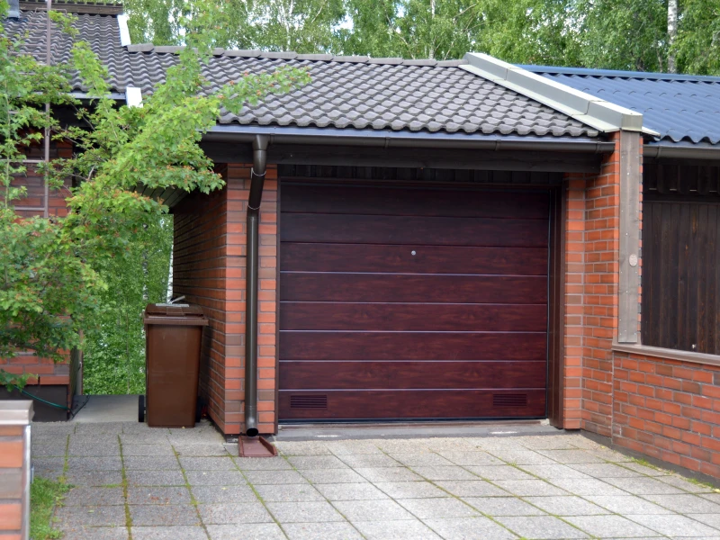 Autotallin nosto-ovi asennettuna Lappeenrannassa — puujäljitelmäpinta mahonki — JK-Ovet