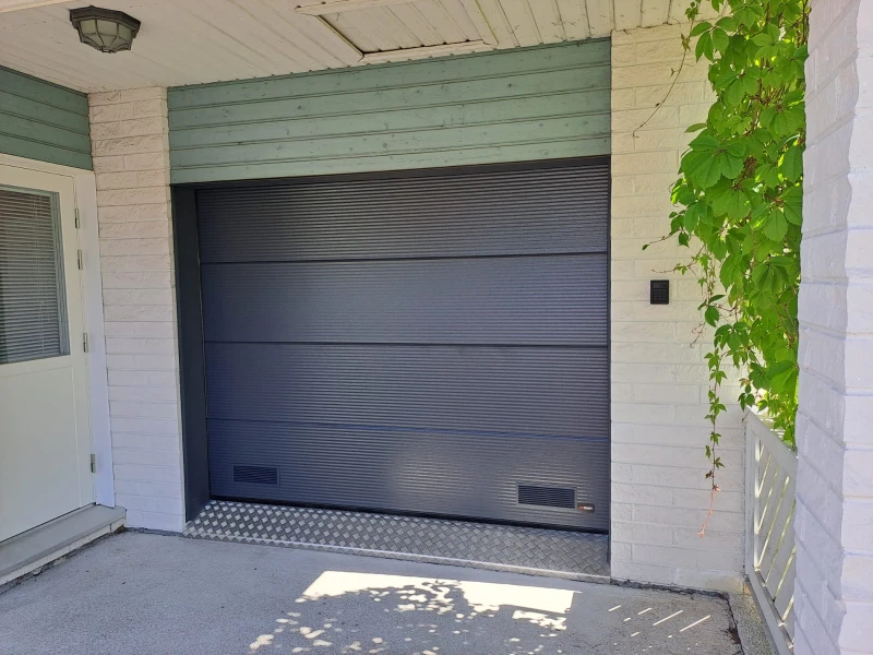 Autotallin nosto-ovi asennettuna Myllykoskella — makroura harmaa RAL 7016 — JK-Ovet