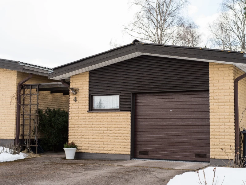 Autotallin nosto-ovi asennettuna peltipielillä Kouvolassa — kapea vaakaura — JK-Ovet