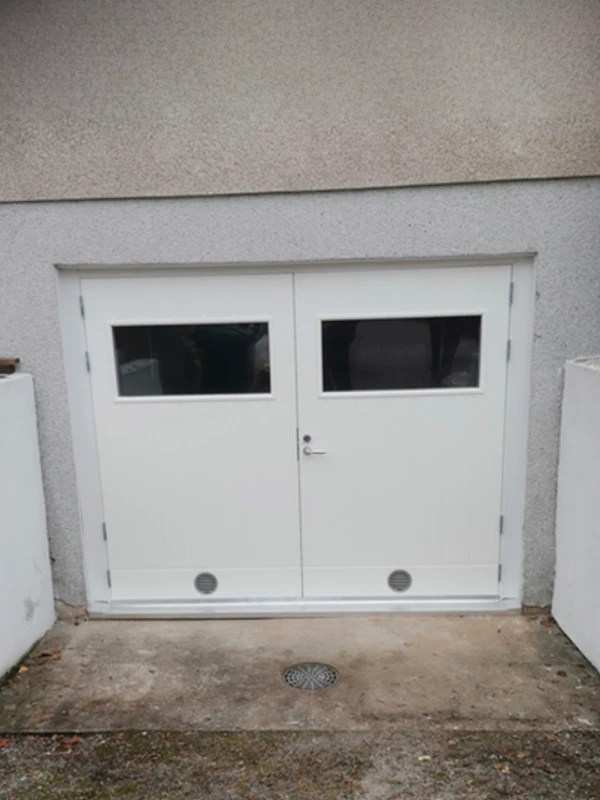 Uusi valkoinen autotallin pariovi ikkunoilla asennettuna