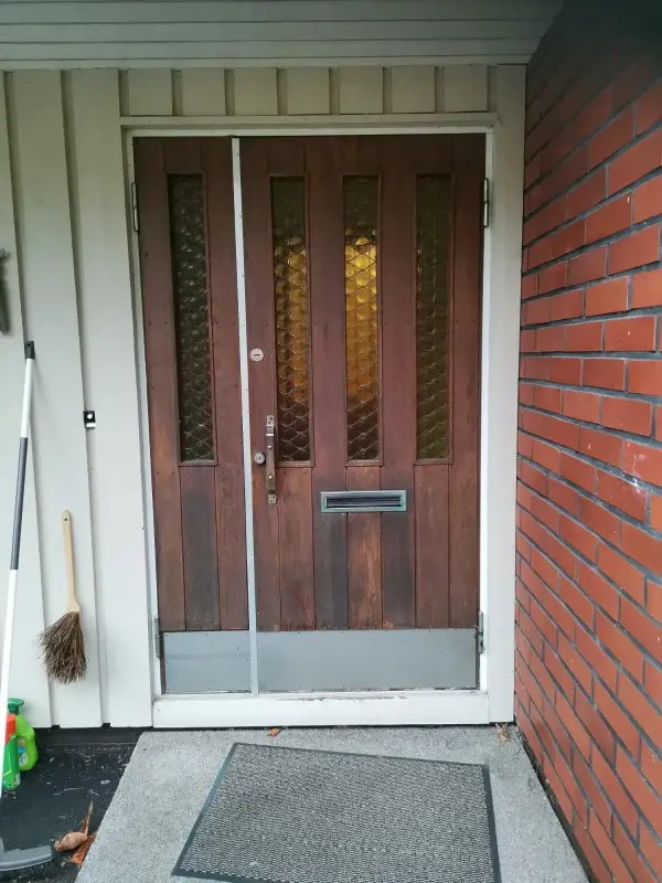 Vanha ulko-ovi avattavalla levikkeellä ennen vaihtoa Hollolassa