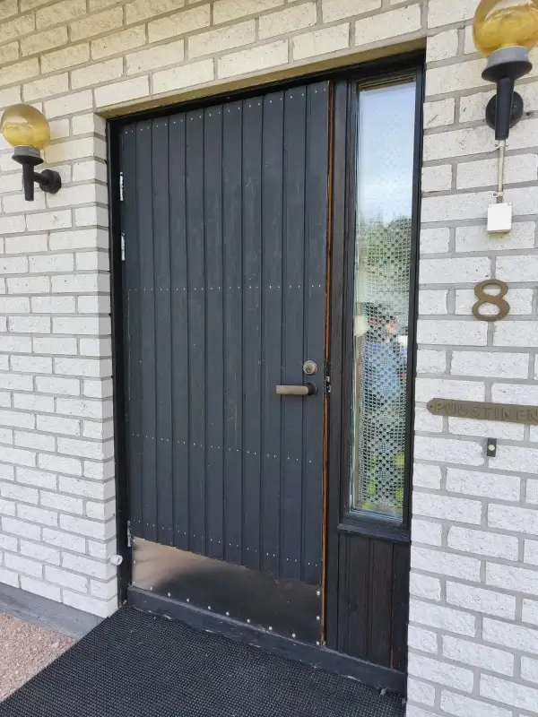 Vanha ulko-ovi sivuikkunalla ennen vaihtoa Valkealassa